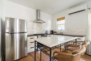 a kitchen with a stainless steel refrigerator and a table at Stay Portland - The Câlin Suite - Posh Local Boutiques & Eateries in Portland