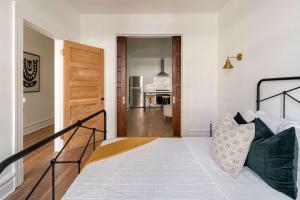 a white bedroom with a bed and a hallway at Stay Portland - 1BR - Walk to Coffee, Brews & NW 23rd Shops in Portland