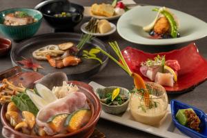 YoriiKAMENOI HOTEL Nagatoro Yorii的桌子上摆着许多盘子食物