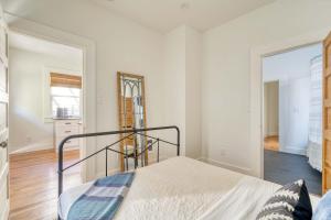 a white bedroom with a bed and a mirror at Stay Portland - The Trésor Suite- Cold Brew & Craft Beers in Portland