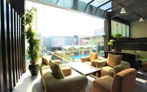 a lobby with couches and a table and a pool at Grage Hotel Cirebon in Cirebon