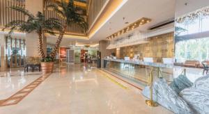 a hotel lobby with a swimming pool and palm trees at Yanji Yanbian International Hotel in Yanji
