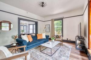 ein Wohnzimmer mit einem blauen Sofa und einem Fernseher in der Unterkunft Stay Portland - Luxury Living on NW 23rd Ave, Walk Score 99 in Portland