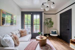 ein Wohnzimmer mit einer weißen Couch und einem Tisch in der Unterkunft Stay Portland - Luxury Living on NW 23rd Ave, Walk Score 99 in Portland