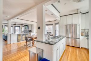 a kitchen with white cabinets and a dining room with a table at 1910 Historic Jessie Morehead House - 98 WalkScore in Portland