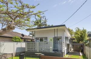 een wit huis met een hek en een hek bij Serenity & Poolside Sun - 400m to Beach in Scarborough