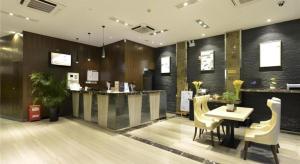 a restaurant with a table and chairs in a room at Metropolo Hotel Hefei Baohe Wandabao Park Metro Station in Hefei
