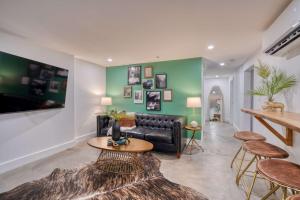 ein Wohnzimmer mit einer schwarzen Couch und einem Tisch in der Unterkunft Stay Portland - 1910 Historic Jessie Morehead House - 98 WalkScore in Portland