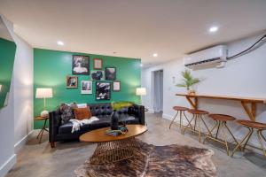 ein Wohnzimmer mit einem schwarzen Sofa und einer grünen Wand in der Unterkunft Stay Portland - 1910 Historic Jessie Morehead House - 98 WalkScore in Portland