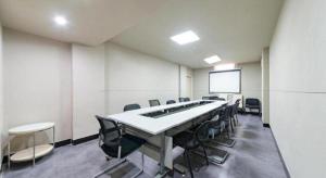 a conference room with a long table and chairs at Jinjiang Inn Huizhou Xihu Lake Shuidong Street River View in Huizhou