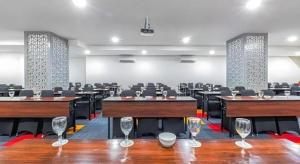 an empty room with tables and chairs and wine glasses at Royal Bay Hotel Makassar in Makassar +92 photos