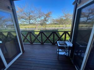 eine Veranda mit einem Stuhl und einem Fenster in der Unterkunft レイクウエスト4-711 in Wada