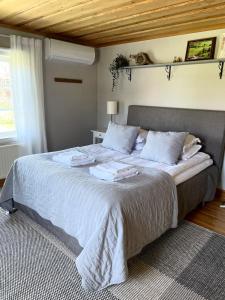 une chambre avec un grand lit avec des draps blancs dans l'établissement Country Escape, Cozy Village Cottage, à Falun