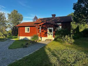 une petite maison en bois avec une allée en gravier dans l'établissement Country Escape, Cozy Village Cottage, à Falun