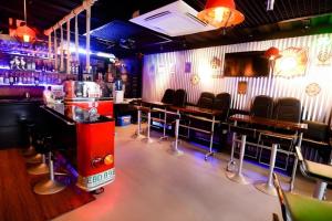 a bar with tables and chairs in a room at Facade Hotel in Baranghauon