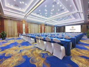 a large banquet hall with blue tables and white chairs at Horizon Hotel in Kunming