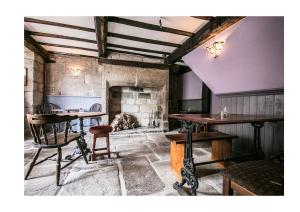 a room with a table and chairs and a fireplace at The Cross Inn in Hebden Bridge