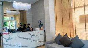 eine Lobby mit einer Theke, an der Leute in einem Salon sitzen in der Unterkunft The Violin - Sriracha in Ban Thung Sukla + 100 Fotos