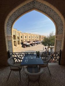 Un arco con una mesa y sillas en un patio en AMIRAN Boutique, en Bukhara