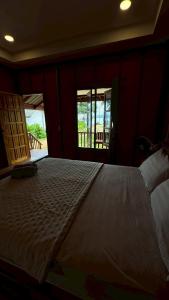 a bedroom with a large bed and two windows at Cheriya bungalow Kohyaonoi in Ban Laem Sai