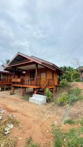 a wooden house with a porch on a field at Cheriya bungalow Kohyaonoi in Ban Laem Sai +47 photos