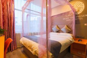 a bed with a canopy in a room at Shell Ganzhou Central Theme Hotel in Ganzhou