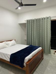 a bedroom with a bed and a ceiling fan at The Lovely Home Stay in Munnar
