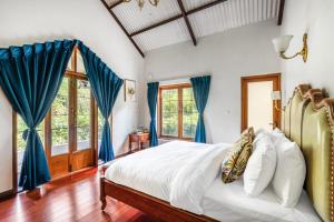 una camera con letto e tende blu di The Winterfel a Yedapalli