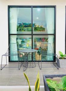 a patio with a table and chairs on a balcony at The Hub Hotel Surin in Surin