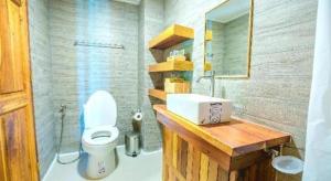 a bathroom with a white toilet and a sink at Burann Bangtanode in Ban Bang Tanot
