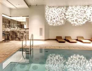 een zwembad met ligstoelen en een eetkamer bij Festival Towers Brisbane in Brisbane