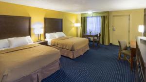 a hotel room with two beds and a desk at Cerulean Hotel, a Running Y Property in Klamath Falls