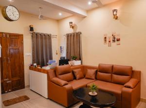 una sala de estar con un sofá y una mesa en Guestland Homestay, en Kochi