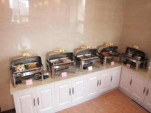 una fila de bandejas de comida en un mostrador en GreenTree Inn Hebei Zhangjiakou Xiahuayuan Xinchen Road Express Hotel, en Dingfangshui