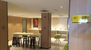 a room with a table and chairs and a kitchen at IU Hotel Tianjin Youyi Road Meijiang Exhibition Meiniu Metro Station in Tianjin