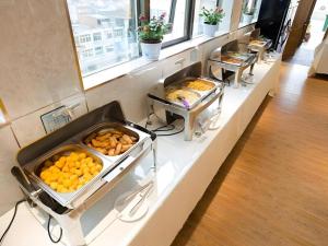 Una línea de buffet con muchos tipos diferentes de comida. en GreenTree Inn Maanshan Hanshan District Jiuwu Square Hotel, en Jiulian