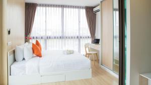 een slaapkamer met een wit bed en een raam bij Connext Residence in Phuket