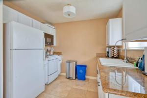 a kitchen with a white refrigerator and a sink at Stay Portland - Adorable Bright 1 Bed Near OHSU in Portland +14 photos