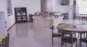a kitchen with a table and chairs and a counter at GreenTree Inn Binzhou Bus Station in Dudian
