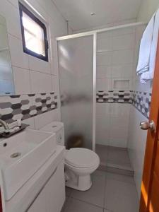 um banheiro com vaso sanitário, chuveiro e pia em Casa Benito Resort 