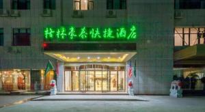 a building with a green sign on the front of it at GreenTree Inn Wuhu Eshan Road University City in Wuhu
