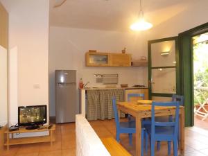 a kitchen and dining room with a table and a television at Il Giardino Ipogeo in Favignana