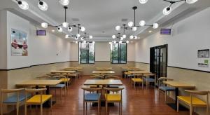 a dining room with tables and yellow chairs at GreenTree Inn Ganzhou Gan County Bus Station in Meilin