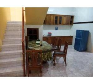 a kitchen with a table and chairs and a blue refrigerator at Algira Homestay Prambanan in Prambanan