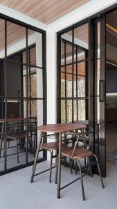 a table and chairs on a patio with windows at Lightstar Modern Villa Mandalika in Kuta Lombok