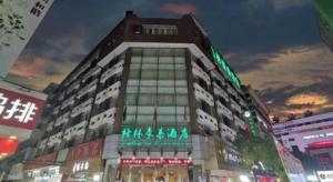 a large building with neon signs in a city at GreenTree Inn Bengbu Huaihe Walking Street in Bengbu