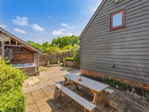 a wooden picnic table in a yard next to a building at Liston Hall Barn in Gosfield