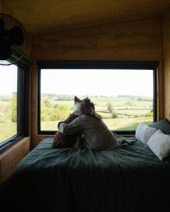 a person sitting on a bed looking out a window at Altair in Holywell