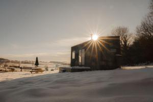 a building with the sun shining on it in the snow at Altair in Holywell