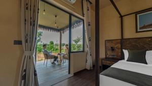 a bedroom with a bed and a couple sitting at a table at Vallora Retreat Jawai Luxuria By Moustache in Bera +17 photos